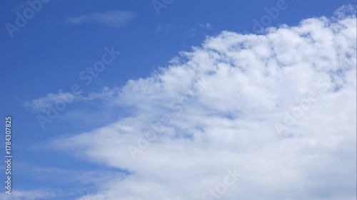 Time lapse of gentle clouds traveling across an open blue atmosphere creating calm visual rhythm and natural flow. Sky harmony.