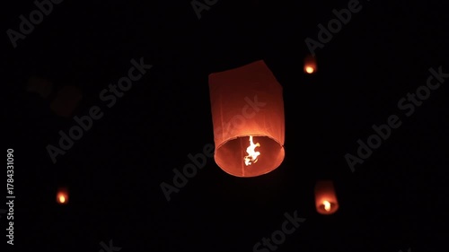 Sky lantern floating in the dark night sky, Tourist floating sky lanterns, Sky lanterns floating on night of Yi Peng, Loy Krathong Festival or Yi Peng Festival in Chiang Mai Thailand. 