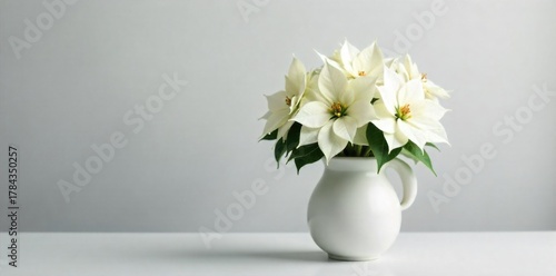 Minimalist modern white poinsettia arrangement in a sleek ceramic vase with clean lines. A minimalist arrangement of white poinsettias in a sleek, matte white ceramic vase, positioned on a smooth,