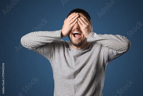 Screaming young man on dark...