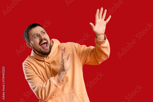 Scared young man screaming ...