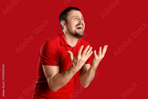 Screaming young man on red ...