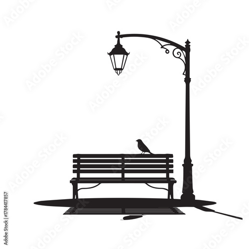 Silhouette of a bird on a park bench under a lamppost