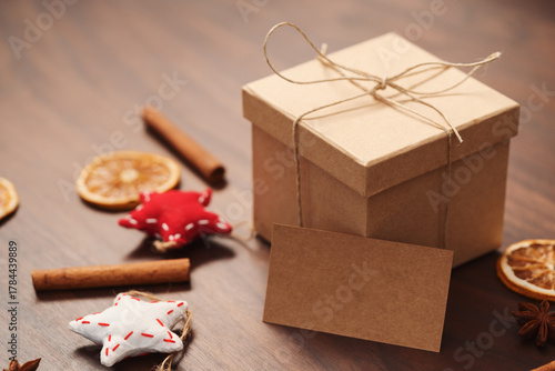 Christmas gift box from eco friendly paper wrapped with natural twine on wood table with natural decorations and 2021 card