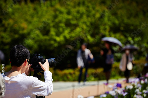Back view of a person taking pictures in the park