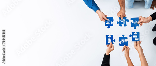 Hands come together to connect puzzle pieces representing teamwork, ethics, and accountability, highlighting the importance of collaboration in achieving business goals. Amity