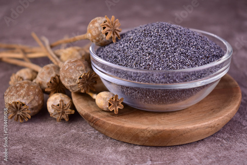 Poppy seeds in a bowl on a gray background. Close-up.
