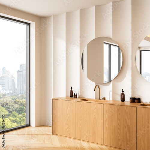 Fototapeta Naklejka Na Ścianę i Meble -  Modern bathroom interior with light wood vanity, round mirrors, and city view through large window, featuring elegant minimalist design concept. 3D Rendering