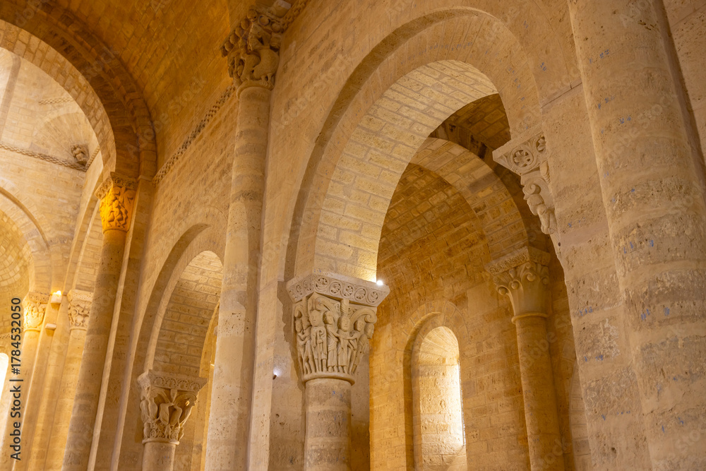 Naklejka premium Romanesque church interior with carved capitals and stone arches in Fromista