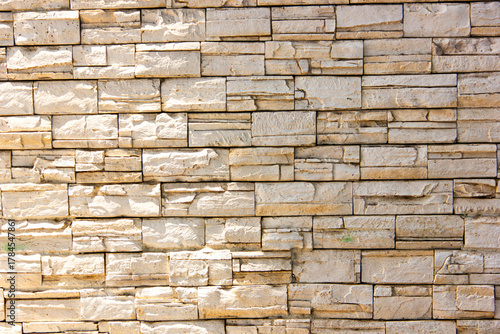 Natural stone wall texture with rough surface and horizontal brick pattern. Perfect for architecture, construction materials, and decorative background design.