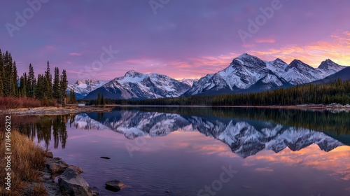 Wallpaper Mural Scenic Snow Capped Mountains Reflected on Calm Lake Surface at Dusk Under Colorful Sky in Wilderness Landscape with Dense Forest and Rocky Shoreline Torontodigital.ca