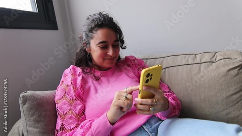 Girl with curly hair checking her social media on her mobile phone
