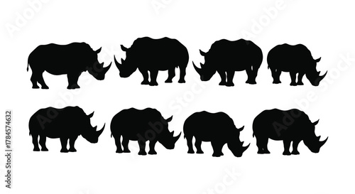 A group of rhinoceros silhouettes standing together