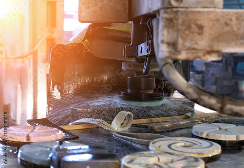 Machine cutting stone tiles in a workshop during daylight hours, showcasing precision craftsmanship and tools