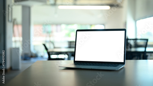 Laptop computer on meeting table with empty screen.