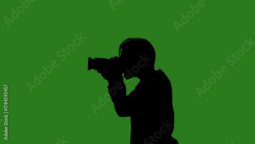 Wallpaper Mural Black isolated silhouette of a man with a camera on a green chroma key background. Minimalist contrast and modern visual composition, mockup. Torontodigital.ca