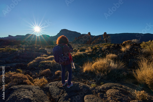 Woman photographer shooting Roques de Garcia with Mount Guajara in the background