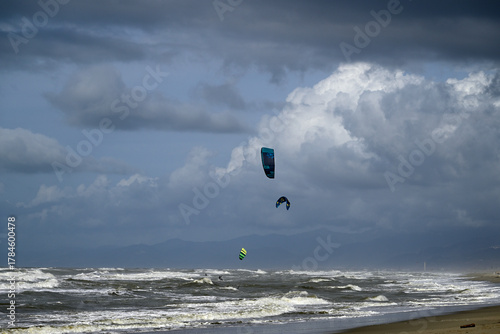 Kitesurfing at italian beach. Some kitesurfers at Torre del Lago beach, tuscany, italy. Some are junping out of the water. Mediterraenean Sea.