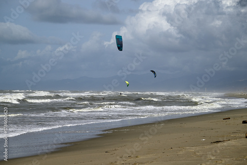Kitesurfing at italian beach. Some kitesurfers at Torre del Lago beach, tuscany, italy. Some are junping out of the water. Mediterraenean Sea.