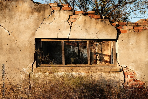 Crumbling Brick Wall with Broken Window in Abandoned Building