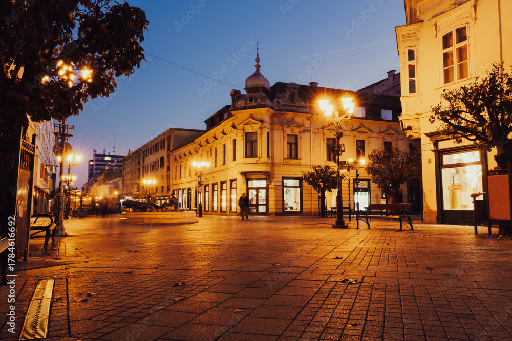 Fototapeta premium Historic city street with warm lights at twilight