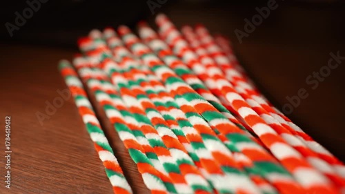 Christmas color theme striped pipe cleaners on dark wooden oak table top in warm candle light