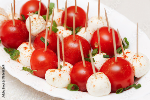 Wallpaper Mural Tomato and mozzarella cheese skewers with herbs on white plate. Fresh appetizer sticks with basil and seasoning. Light snack for party or catering event. Torontodigital.ca