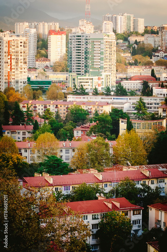 A dramatic cityscape with residential and industrial buildings in the evening twilight. Vertical photograph.