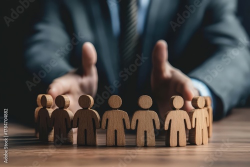 Shielding Support: A person in a suit, symbolizes the concept of protection and support by surrounding a circle of wooden figures, creating a visual metaphor for unity and safeguarding