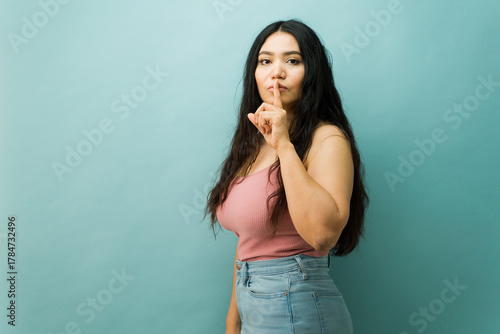 Bild auf Leinwand Serious woman asking for silence, keeping a secret