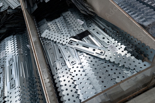 Collection of metal brackets and connectors stored in a hardware store in a well-organized display for easy access and selection by customers