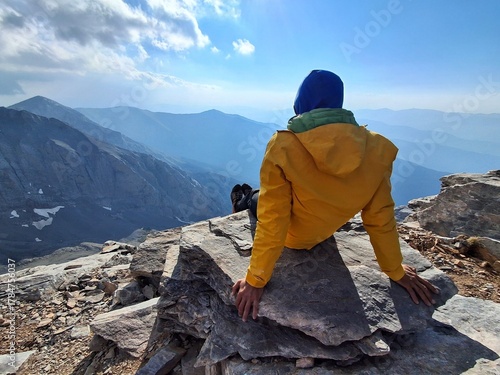 Hiker in  a yellow jacket looking at a mountain view, Mount Olympus, Greece