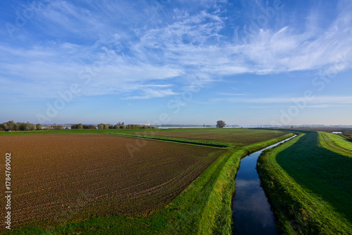 High-Angle View of a Dutch Polder Landscape with Tilled Fields and a Straight Canal under a Clear Blue Sky in the Biesbosch, Netherlands