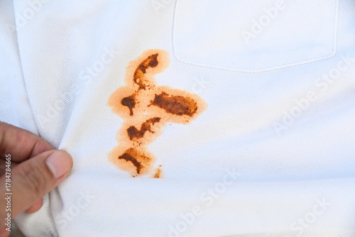 hand showing dirty sauce food stain on white shirt from eating in daily life