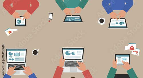 team collaboration using technology reviewing charts and reports on laptops and tablets in a meeting showcasing synergy and teamwork