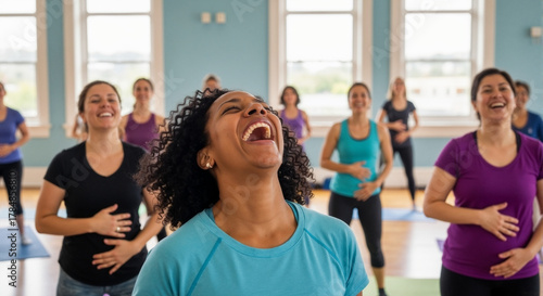 Joyful African American woman laughing during a group fitness class. Diverse women enjoying a laughter yoga session together in a bright studio. Happiness and wellness concept