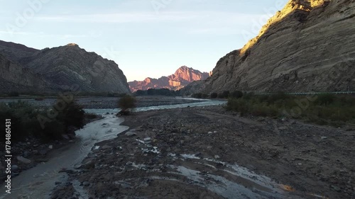 drone shot of two asian landscape photographers taking photos of sunrise over mountain in tianshan grand canyon, xiniang, china
