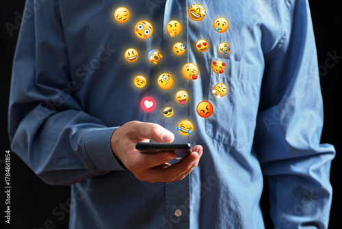 Man using smartphone sending emojis for social media communication