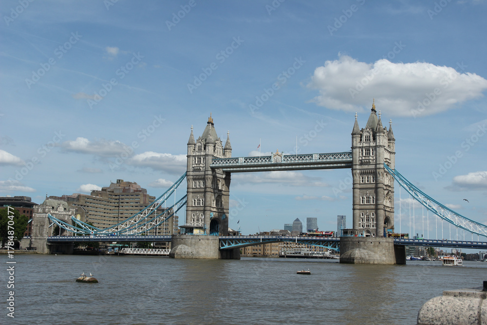 Obraz premium Tower Bridge spans the River Thames in London, showing its iconic structure against a clear blue sky