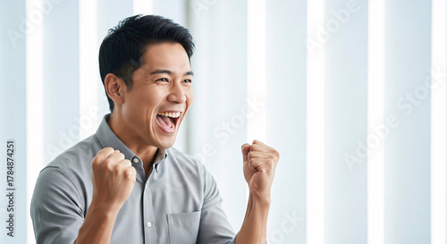 Asian Man Success Celebration Achieving Goals Overcoming Challenges Demonstrating Enthusiasm Optimism Energetic Expression Positive Outlook Joyful Moment Triumphant Gesture