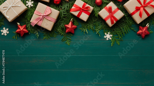 Christmas Gifts and Evergreen Branches on Green Wooden Background