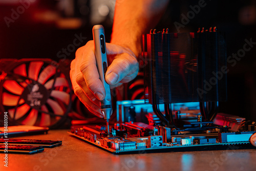 A set of parts for assembling and repairing a computer. Angle from above, everything is on the table, laid out, neon light