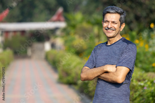 Confident Indian Senior Man with Arms Crossed, Standing on Park Path Portrait