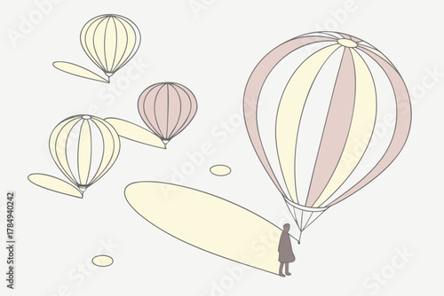 Person holding a large hot air balloon with smaller balloons in the background