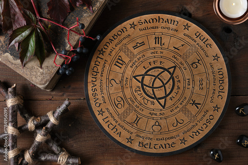 Konstfotografi Mystic Wheel of the Year with runes and ritual items on a wooden table