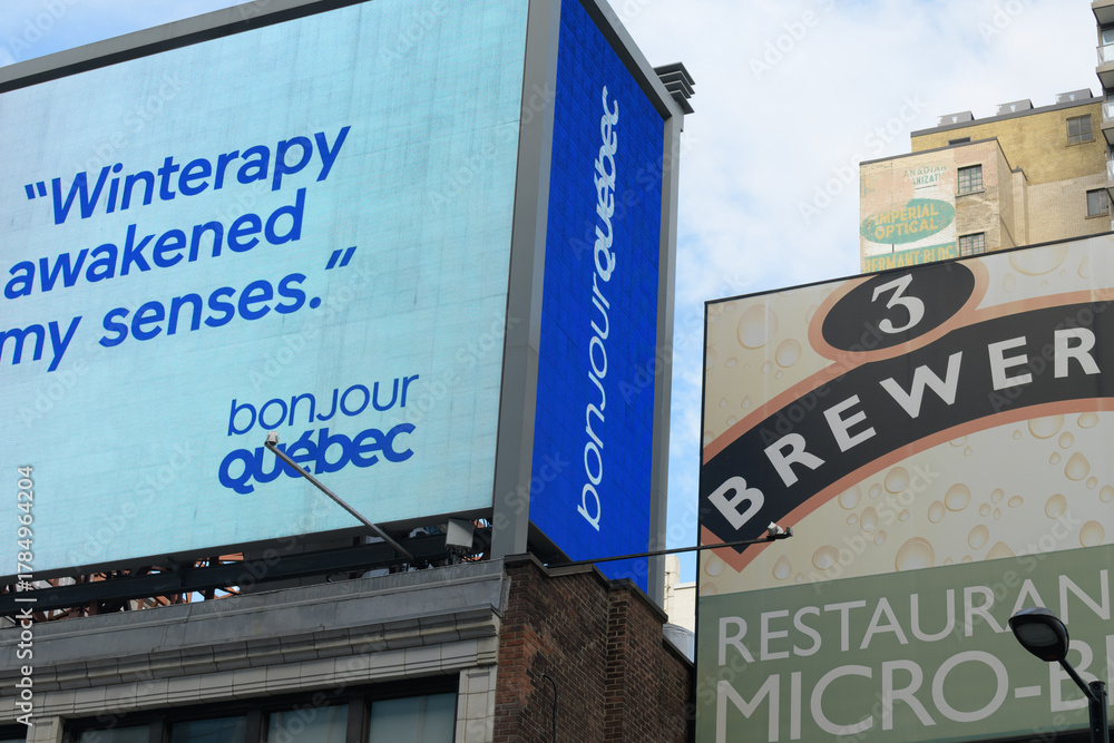 Fototapeta premium detail of electronic sign of Bonjour Québec, official brand and trademark used by the Ministère du Tourisme du Québec (Quebec's Ministry of Tourism) and sign above 3 Brasseurs MicroBrewery - Toronto