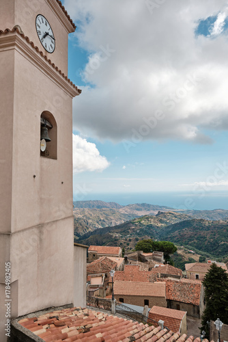 Bell tower and rooftops of the historic hilltop village of Bova, Calabria, southern Italy, with scenic view of the Aspromonte mountains and Ionian Sea in the background