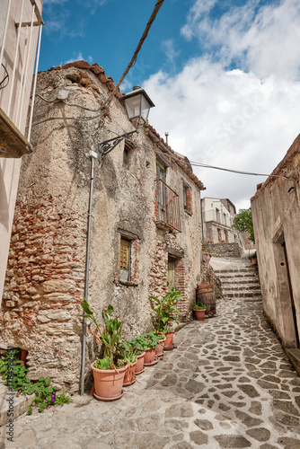 Tableau sur toile Traditional narrow street with old stone houses, potted plants and stairs in the
