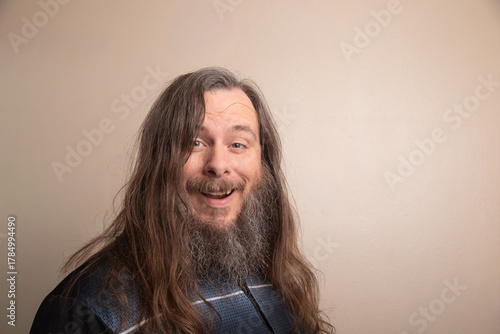 A man with a beard and long hair is smiling