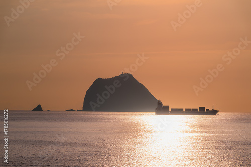 A stunning video of a cargo ship sailing past Keelung Islet at sunrise Filmed from Waishuangxi Beach Keelung Taiwan creating a dramatic and serene seascape.